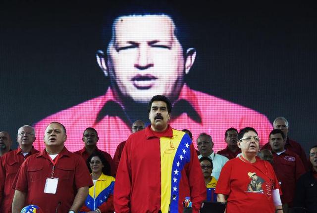 尼古拉斯·马杜罗总统(中)于2014年7月31日出席委内瑞拉统一社会主义党年度大会，地点在加拉加斯的军营山。那里摆放着前总统雨果·查韦斯(大屏幕)的遗体。