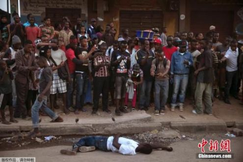 当地时间2014年12月18日，塞拉利昂东部Koidu，疑似埃博拉患者遗体横躺街头引民众围观。