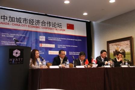 贾晓霞（左一）在加拿大一次公开活动中坐在主席台上。