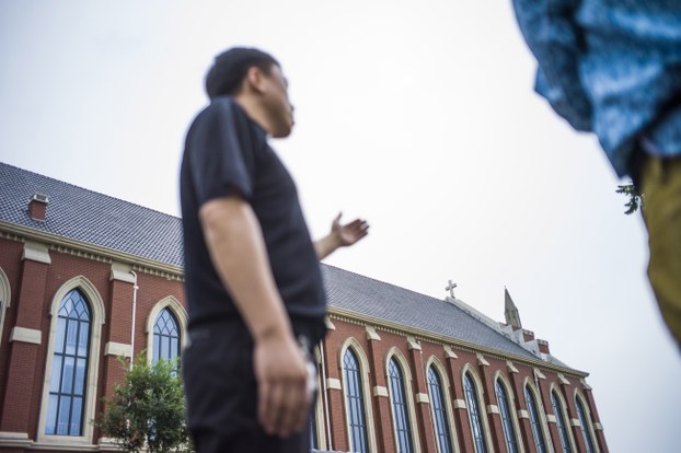 图片：天津一天主教教堂的牧师在新建的教堂外接受采访，称感谢当局斥资1900万元兴建该教堂。(法新社图片)