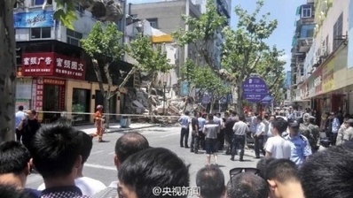 7月27日中午，杭州市富阳区一处居民楼突然整体倒塌，底层一家服装店正在营业，有4名被困人员被救出，具体被困人数不明。(网络图片)