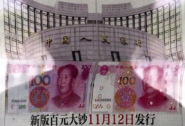 北京有人在街头报栏阅读报纸上关于中国央行宣布将发行百元新钞的消息（2015年8月11日）