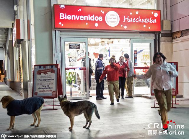 图为智利圣地亚哥民众跑到户外避险。