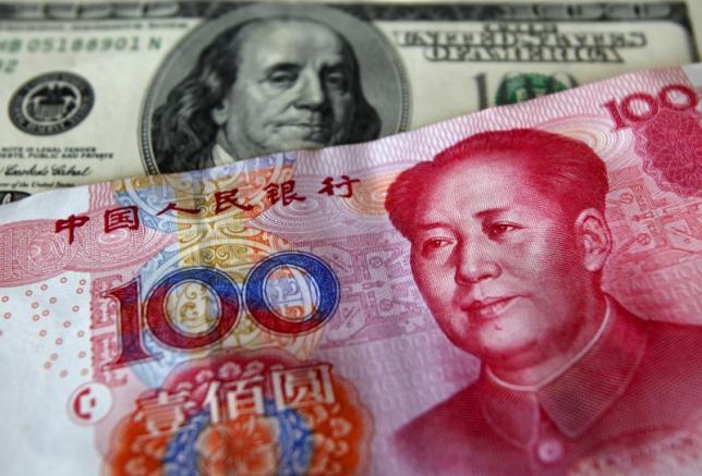 A yuan banknote is displayed next to a U.S. dollar banknote (back) at a money changer inside the Taoyuan International Airport in this March 18, 2010 file photo.  REUTERS/Nicky Loh/Files