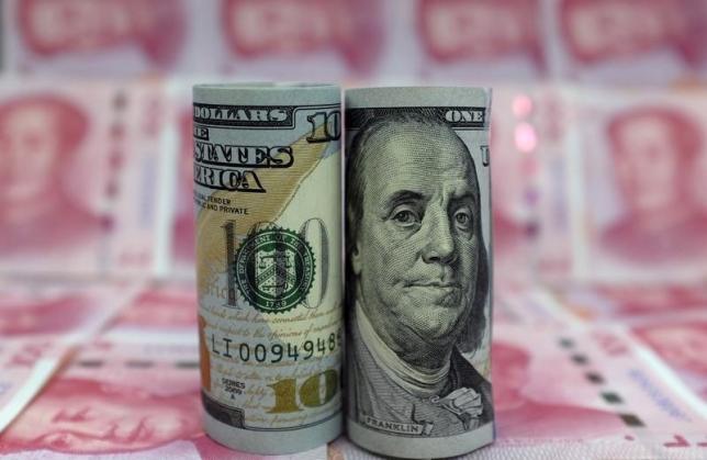 图为以人民币为背景拍摄的美元现钞。REUTERS/Jason Lee