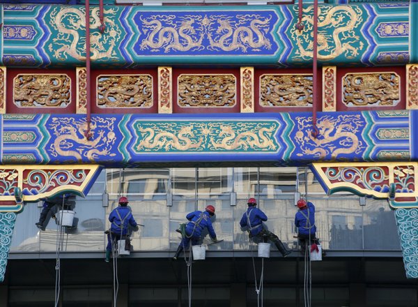 工人们在清洁北京一家国有银行的窗子。Kim Kyung-Hoon/Reuters