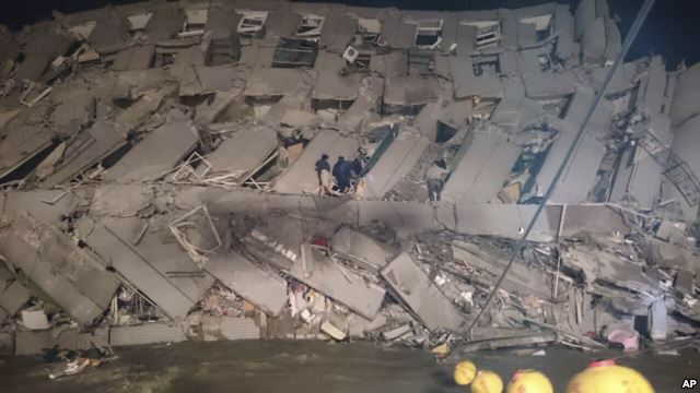 救援人员进入台南市倒向一侧的办公楼。（2016年2月6日）