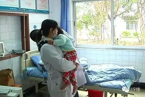 金塘镇中心卫生院的护士抱着孩子