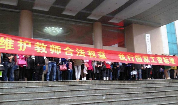 2016年4月20日，湖南省沅江市多名中小学教师，因不满被政府克扣工资，多名教师在市委外拉起横额抗议，要求领导会见他们。（老师摄）