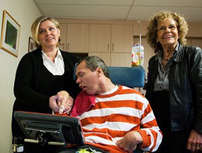 “昏迷”23年的胡本与母亲和治疗师在一起。(网络图片)