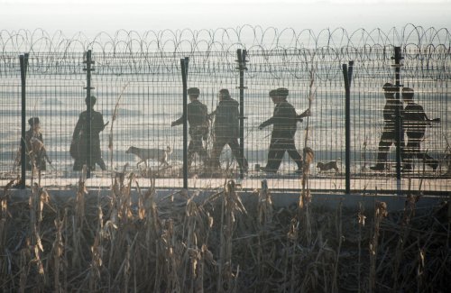2016年2月10日，朝鲜士兵在朝鲜小镇新义州与对面的中国边境城市丹东之间的边界围栏附近进行巡逻。（图片来源：Getty Images）