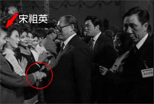 演出后上台握手时，江泽民攥著宋祖英的手不愿撒开，总是两眼直勾勾地望着她。（网络图片）