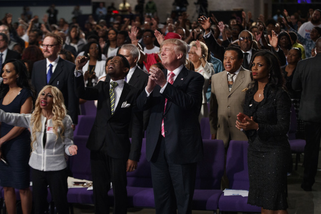 川普（前排右二）3日到底特律非裔大信心国际教堂参加聚会并发表演说。 （美联社）