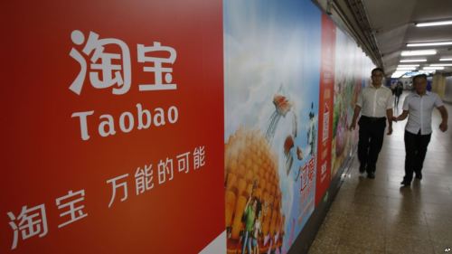 人们走过北京地铁站里淘宝的手机APP宣传广告。（网络图片）
