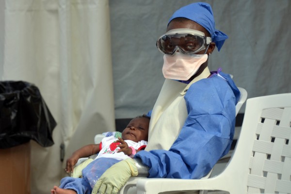 利比里亚的医疗人员，正在照顾一名感染埃博拉病毒的婴孩。（AFP）