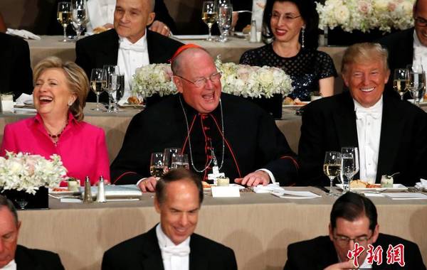 今年10月20日，希拉里和特朗普参加阿尔弗雷德·史密斯纪念基金会年度晚宴两人中间是主办人：美国天主教枢机主教蒂莫西·多兰（Timothy Dolan）