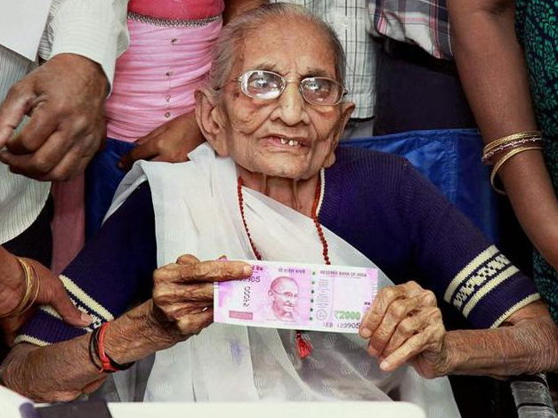 11月15日，印度总理莫迪的母亲向记者展示兑换的2000卢比面值的钞票。（图片来源：印度媒体）